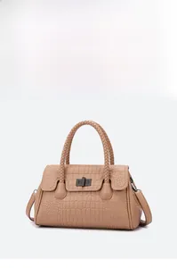 Macro view of brown faux-crocodile texture leather and woven handle of the handbag