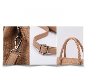 Close-up of khaki crocodile-embossed leather texture with metallic hardware and woven handle