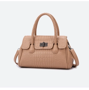 Detailed view of khaki crocodile pattern handbag with woven handles and metal lock