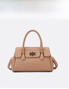 Detail of khaki crocodile pattern handbag with woven handle and metallic twist lock