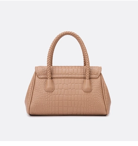 Close-up of crocodile pattern embossed texture and woven handle on the camel tote bag