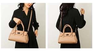 Detail of beige crocodile embossed tote bag with woven ring handle and metal clasp