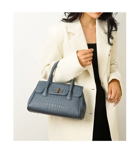 Detail of navy blue crocodile embossed leather handbag with woven handles and metal lock