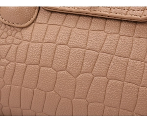 Macro view of brown crocodile embossed leather texture with fine stitching details