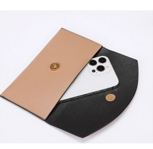 Detail view of slim envelope wallet with bicolor leather and magnetic gold button closure