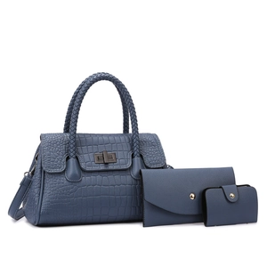 Detail of blue crocodile pattern tote bag set with woven handles and metal twist lock