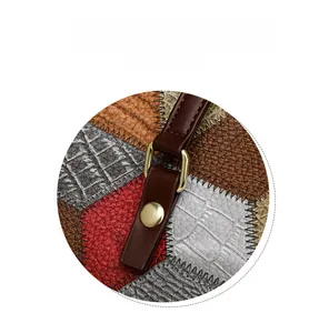 Detail display of patchwork tote bag with crocodile texture and gold metal buckle