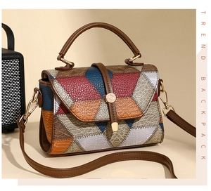 Detail of color-block patchwork handbag with lychee pattern leather and gold hardware