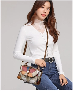 Close-up of color-block patchwork leather handbag with embossed texture and metal clasp
