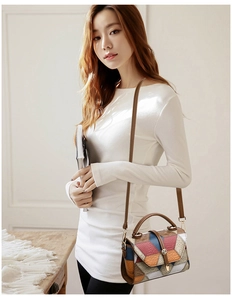 Detail of color-block patchwork leather handbag with geometric patterns and brown strap