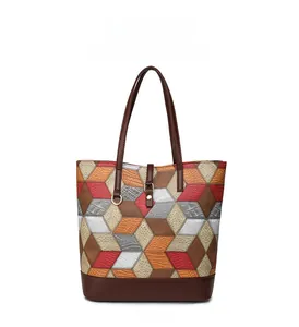 Close-up of geometric patchwork tote bag with crocodile and lychee textured faux leather