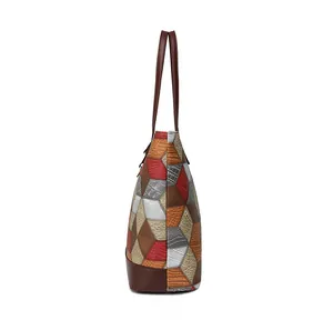 Side view detail of large multi-color patchwork tote bag with faux crocodile leather texture