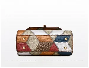 Detail view of the handbag base showing protective gold studs and multi-textured patchwork