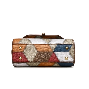 Bottom view of stylish patchwork handbag with gold rivets and textured leather pattern