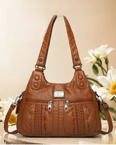 Detail of brown faux leather handbag showing soft pleated texture and double zipper pockets