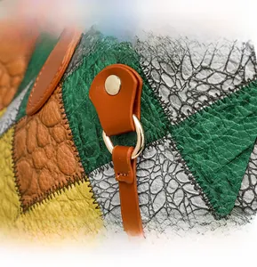 Détail de l'anneau en D doré et des coutures en cuir multicolore sur un sac à main tendance