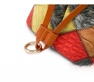 Gros plan d'un sac en cuir gaufré multicolore avec anneau doré et cordon de serrage