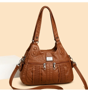 Detailed view of brown washed leather texture with woven strips and silver hardware