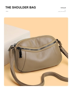 Detail of the textured lychee leather grain and shiny gold hardware on the shoulder bag