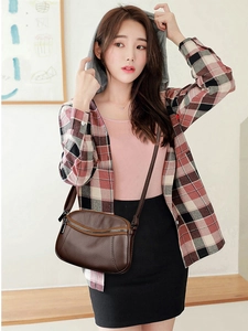 Detail of dark brown leather crossbody bag with litchi grain and adjustable strap