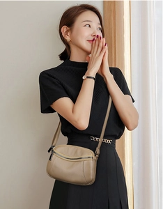 Close-up of litchi texture coffee leather crossbody bag with adjustable shoulder strap