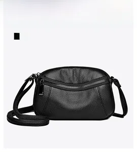 Close-up of black lychee grain leather crossbody bag featuring gunmetal zipper details