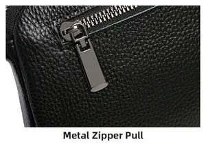 Macro shot of gun-black metal zipper puller on black lychee grain leather handbag