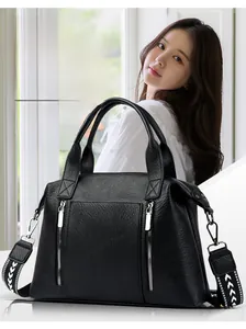 Detail of black faux leather tote bag with dual zippers and geometric pattern strap