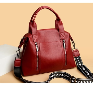 Detail of burgundy tote bag with pebble texture and geometric woven shoulder strap