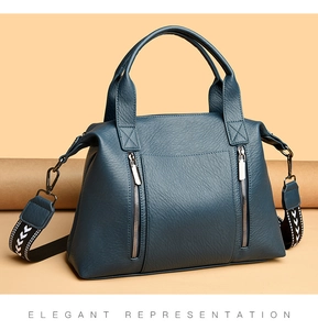 Detail of dark blue lychee grain leather tote with decorative zippers and woven strap