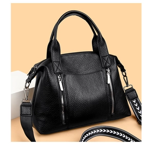 Detail of black pebbled leather tote with silver zippers and geometric woven strap