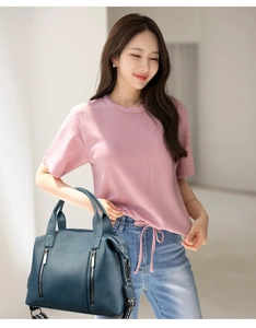Detail of navy blue pebble leather tote bag featuring dual zippers and adjustable strap