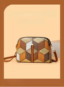 Detail of vintage patchwork crossbody bag featuring geometric patterns and metal zipper