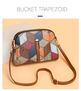 Detail of color-blocked patchwork leather handbag with dual zippers and gold hardware