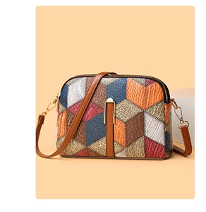 Detailed view of the multi-textured patchwork shell bag with golden hardware details