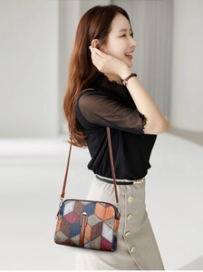 Detail of color-block crossbody bag with geometric 3D pattern and thin brown strap