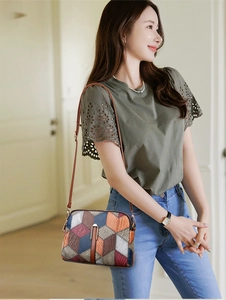 Close-up of a multi-color patchwork crossbody bag with ostrich and snake skin texture