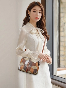 Close-up of ethnic style small crossbody bag with 3D geometric pattern and metal lock