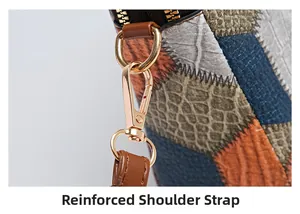 Detail view of reinforced shoulder strap with gold metal lobster clasp on patchwork bag