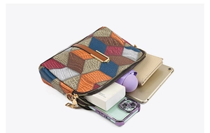 Detail showing large capacity of color-block crossbody bag with dual zipper compartments