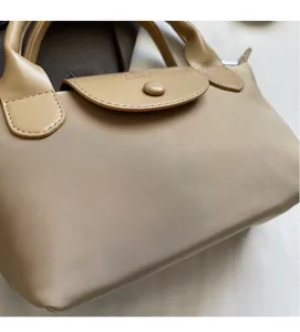 Detail of khaki nylon fabric texture with premium leather flap and branded metal button