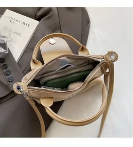 Interior view showing the large capacity and herringbone lining of the khaki crossbody bag
