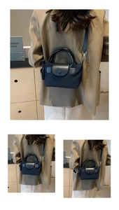 Detail of dark blue nylon handbag with leather flap and detachable crossbody shoulder strap