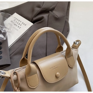 Detail of two-tone nylon handbag with leather flap and adjustable shoulder strap