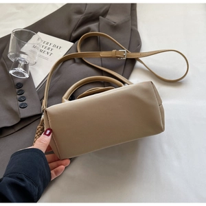 Close-up of khaki nylon Boston bag with leather handles and metallic buckle details