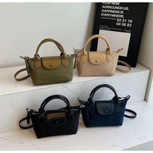 Mini nylon handbags in four colors displayed on marble steps with crossbody straps