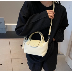 Detail of cream white mini crossbody bag with top handle and fashion logo lettering
