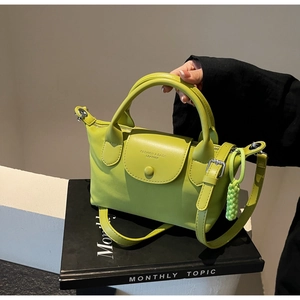 Detail of neon green nylon handbag featuring embossed logo and woven rope accessory