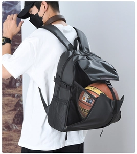 Detail view of black sports backpack with a front mesh pocket holding a basketball