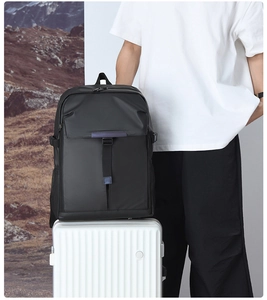 Detail of waterproof black business backpack secured on a white striped suitcase